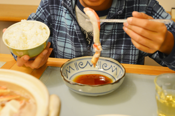 子供が蟹のむき身を食べるところ